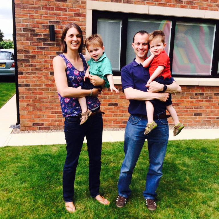 Image of Katie with her partner holding their twin boys